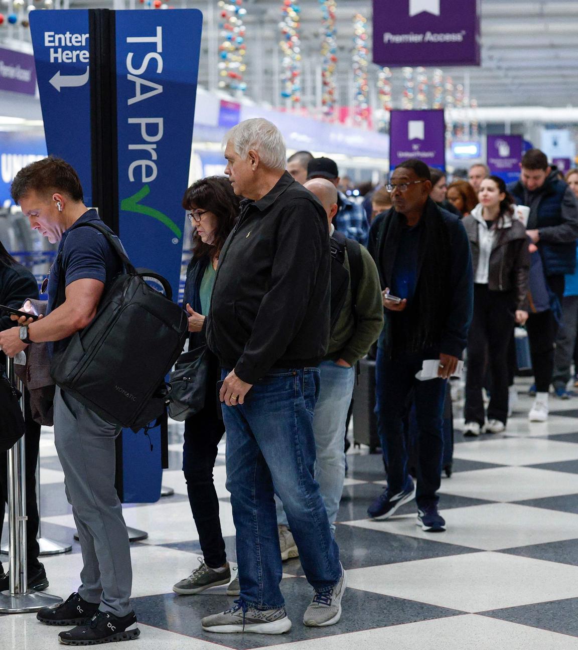 Reisende warten am 7. November 2025 in einer Schlange an einer Sicherheitskontrolle am O'Hare International Airport in Chicago, Illinois. 