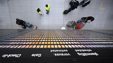 Fluggäste stehen unter einer Anzeigentafel im Terminal 2 des Flughafens in München am 07.06.2025.