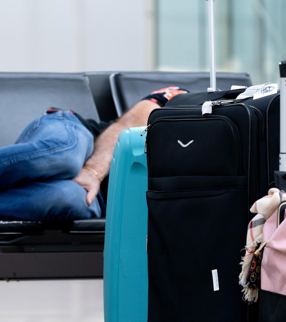 (Symbolbild) Ein Passagiert wartet am Flughafen auf einer Bank auf den weiterflug.