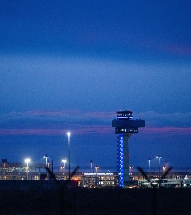 In der Morgendämmerung landet ein Flugzeug am Flughafen Berlin Brandenburg BER.
