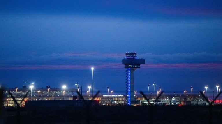 In der Morgendämmerung landet ein Flugzeug am Flughafen Berlin Brandenburg BER.
