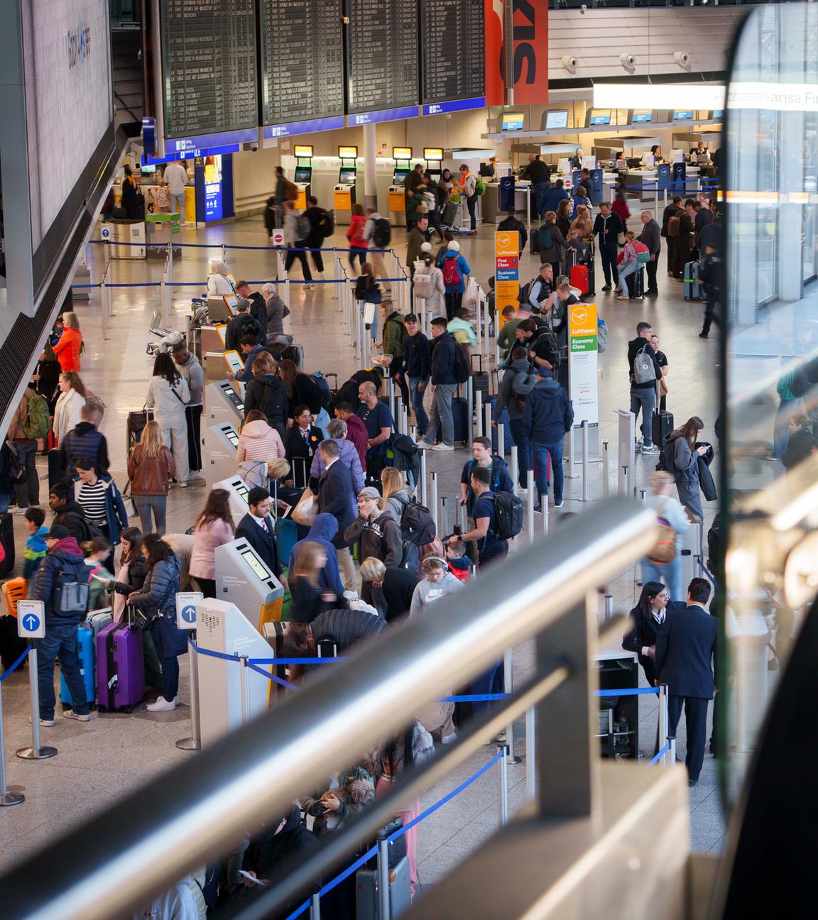 Im Terminal 1 des Rhein-Main Flughafen sind Reisende unterwegs.