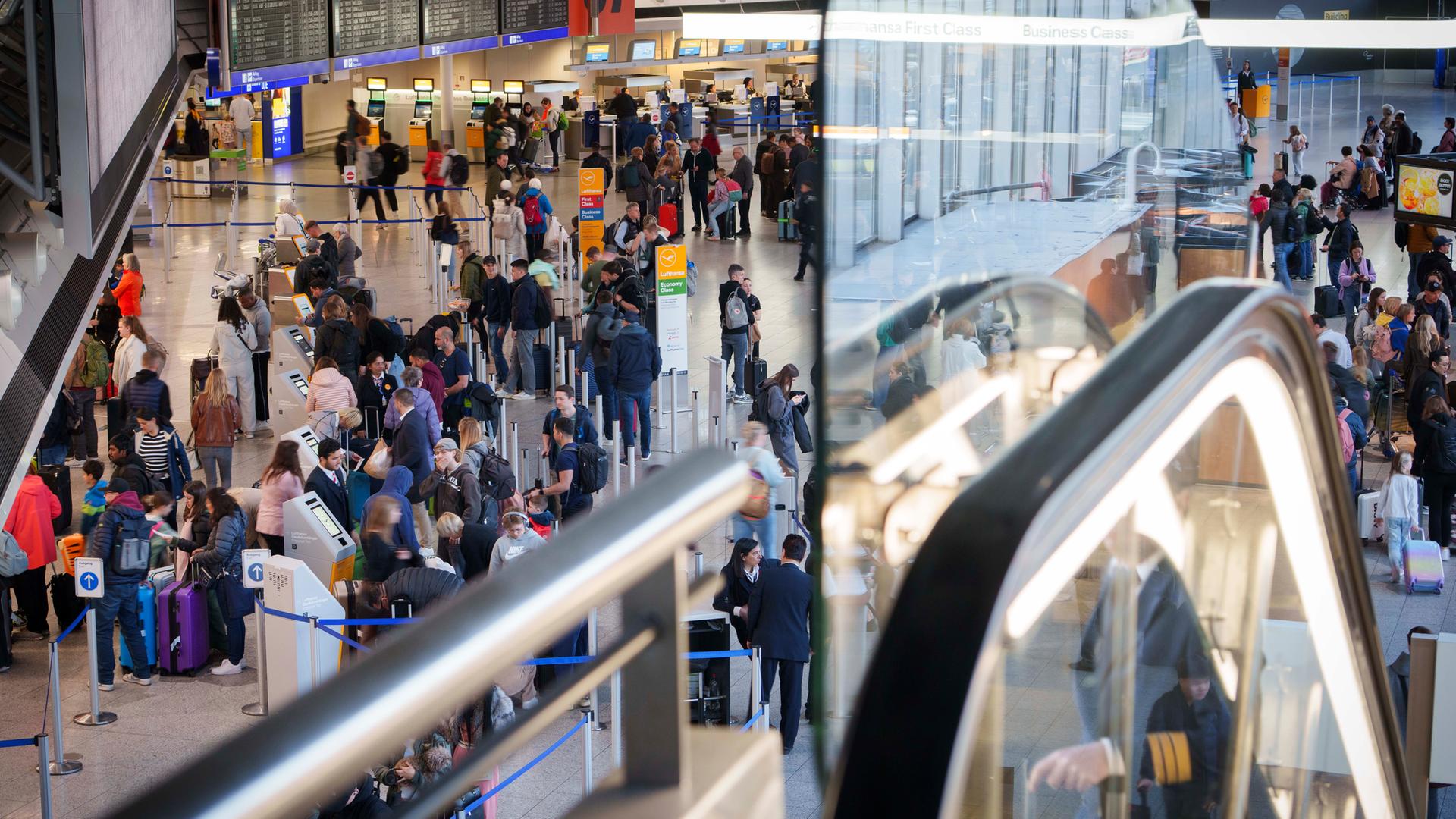 Im Terminal 1 des Rhein-Main Flughafen sind Reisende unterwegs.