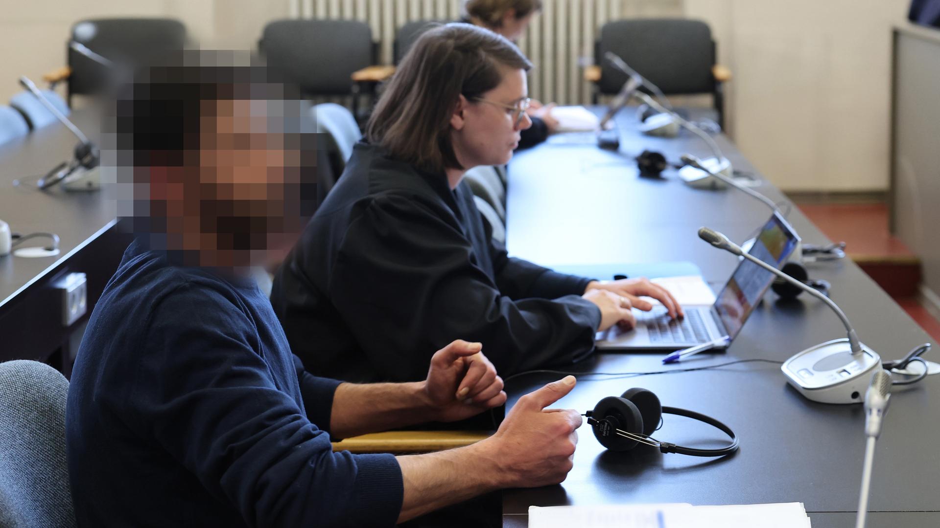 Der Angeklagte und seine Rechtsanwältin Anna Carlotta Bloch sitzen kurz vor Beginn der Verhandlung in einem Gerichtssaal des Strafjustizgebäudes in Hamburg