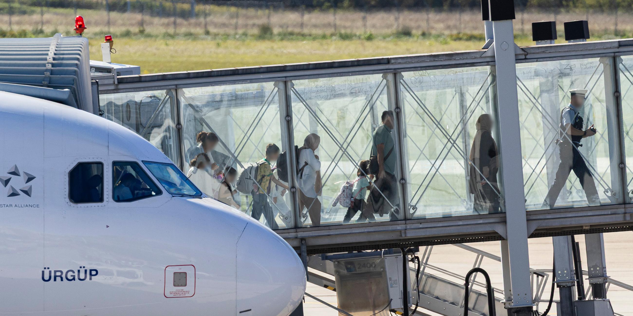 Menschen verlassen ein Flugzeug, welches zuvor auf dem Flughafen Hannover-Langenhagen gelandet ist.
