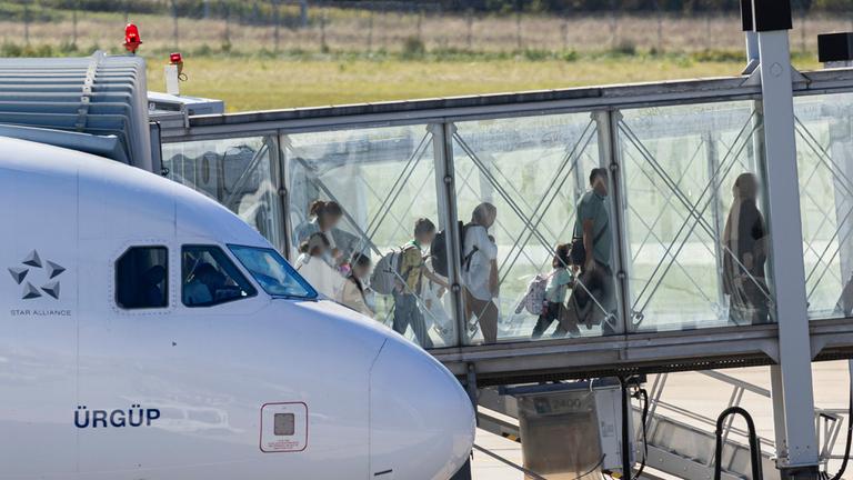 Menschen verlassen ein Flugzeug, welches zuvor auf dem Flughafen Hannover-Langenhagen gelandet ist.