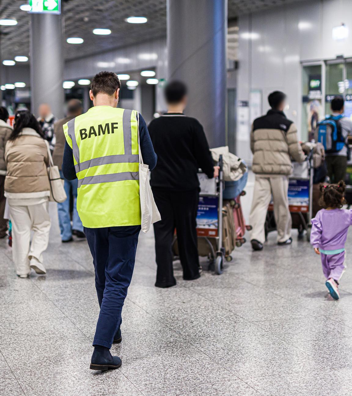 Niedersachsen, Langenhagen: Menschen aus Afghanistan, die zuvor mit einem Flugzeug auf dem Flughafen Hannover-Langenhagen gelandet sind, werden von einem Mitarbeiter des Bundesamtes für Migration und Flüchtlinge (BAMF) durch den Flughafen begleitet.