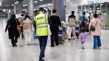 Niedersachsen, Langenhagen: Menschen aus Afghanistan, die zuvor mit einem Flugzeug auf dem Flughafen Hannover-Langenhagen gelandet sind, werden von einem Mitarbeiter des Bundesamtes für Migration und Flüchtlinge (BAMF) durch den Flughafen begleitet.