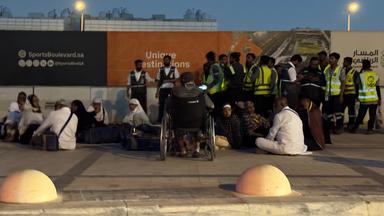 Menschen versammeln sich vor einer U-Bahn-Station an der Straße zum internationalen Flughafen King Khalid in Riad, Saudi-Arabien.
