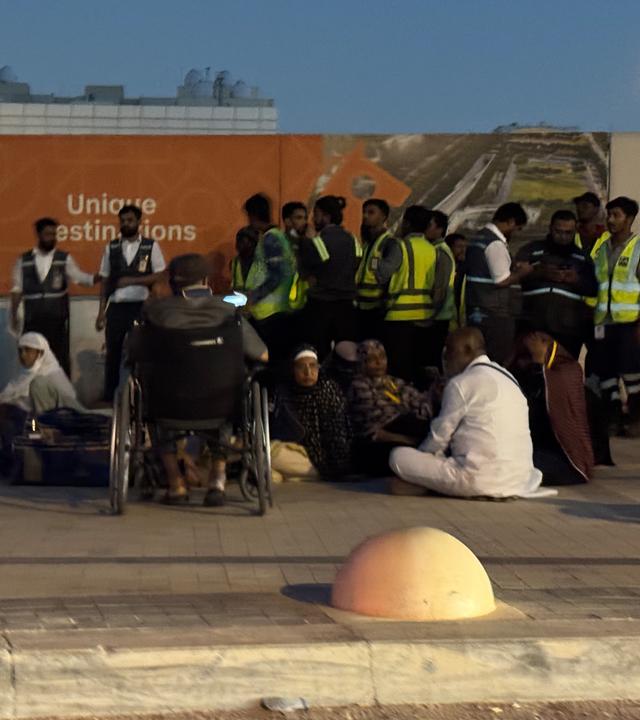 Menschen versammeln sich vor einer U-Bahn-Station an der Straße zum internationalen Flughafen King Khalid in Riad, Saudi-Arabien.