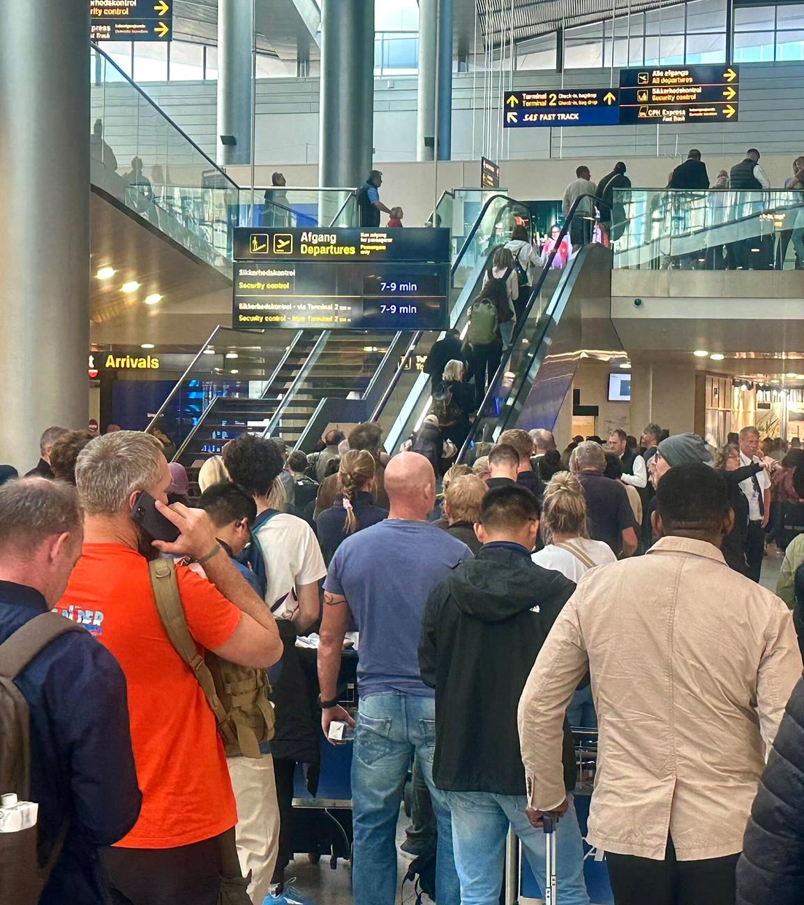Reisende warten am Flughafen in Kopenhagen an einem Service-Schalter
