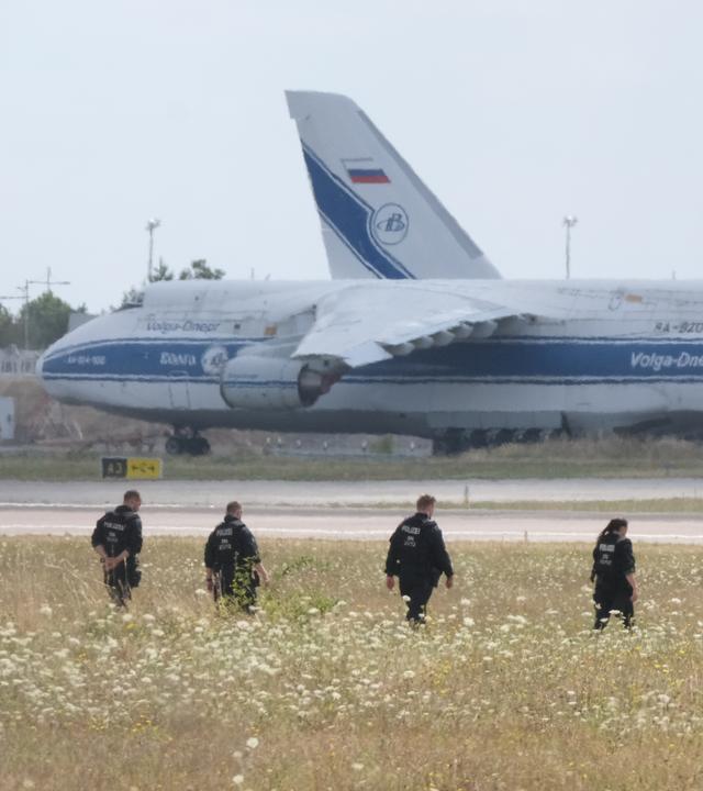 Polizisten gehen über eine Wiese auf dem Gelände des Flughafen-Leipzig am 07.08.2026.