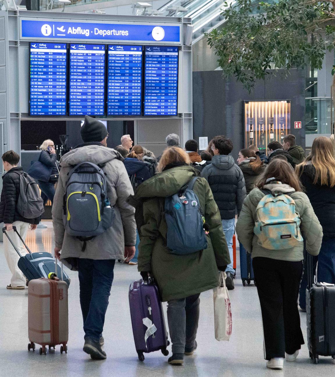 Passagiere gehen durch die Flughafenhalle.