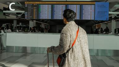 Ein Reisender sieht sich am Samstag, 8. November 2025, den Flugplan am LaGuardia International Airport in New York an.