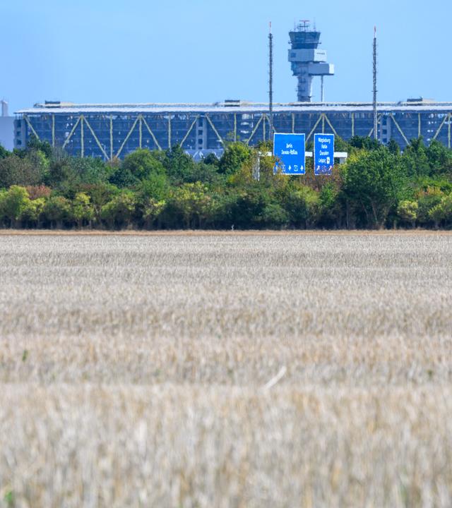 25.08.2026, Sachsen-Anhalt, Kabelsketal: Blick über ein abgeerntetes Feld bei Kabelsketal zum Flughafen Leipzig/Halle. Kanzler Merz (CDU) hat angekündigt, dass sich die Bundesregierung demnächst zu Erkenntnissen über die Urheber des Vorfalls mit einer Sprengstoff-Drohne auf dem Flughafen Leipzig/Halle am 4. August äußern will.