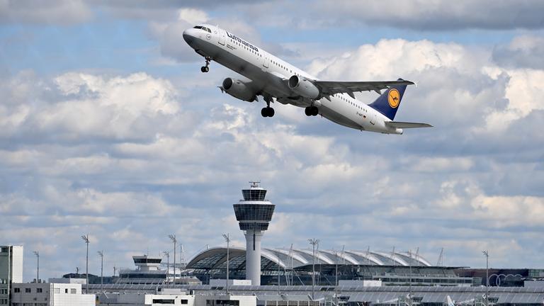 Lufthansa-Flugzeug startet am Flughafen München, sonniger Himmel mit Wolken