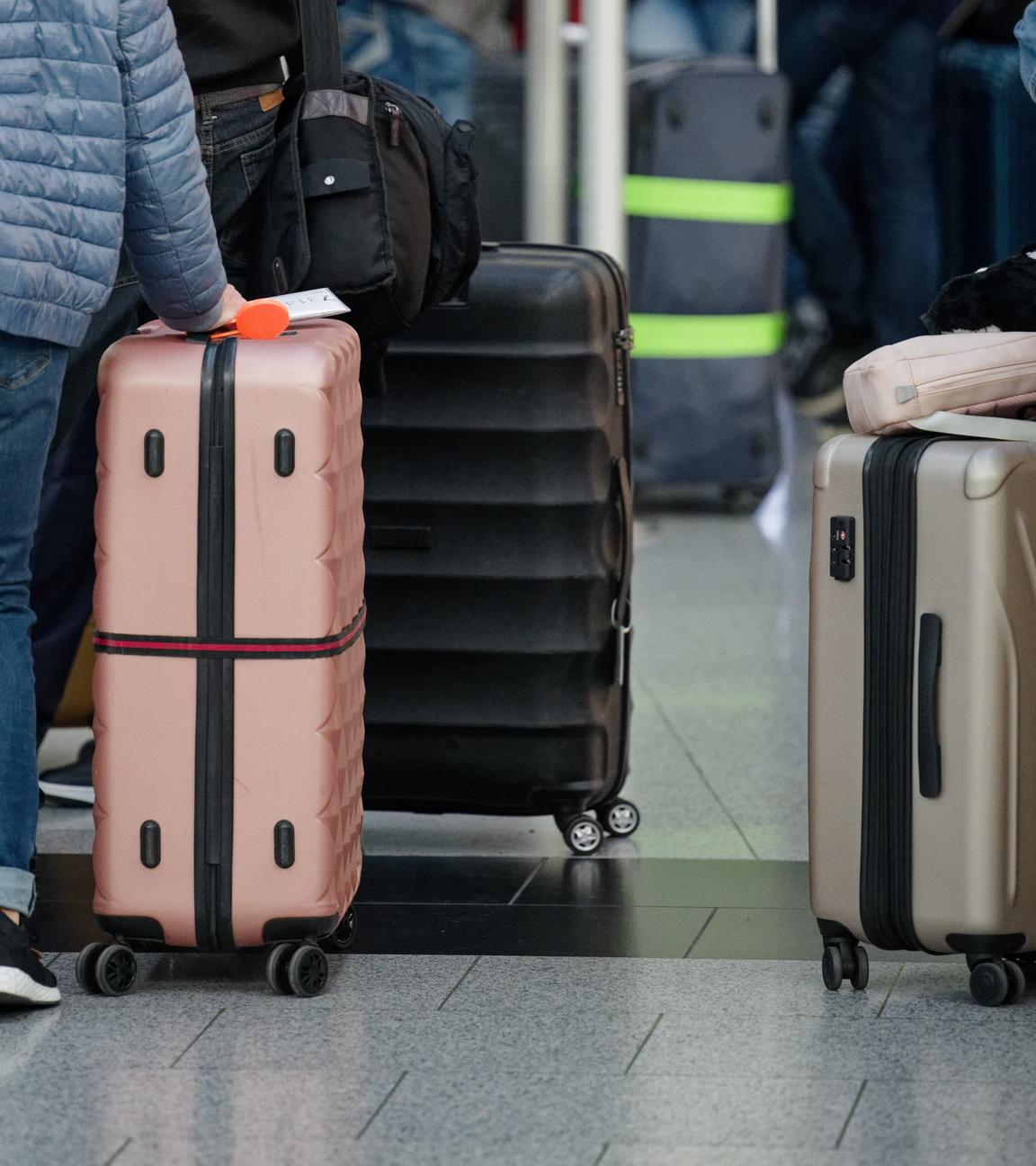 12.04.2025, Nordrhein-Westfalen, Landesweit: Fluggäste stehen in der Abflughalle im Flughafen Düsseldorf mit ihrem Gepäck vor den Schaltern.
