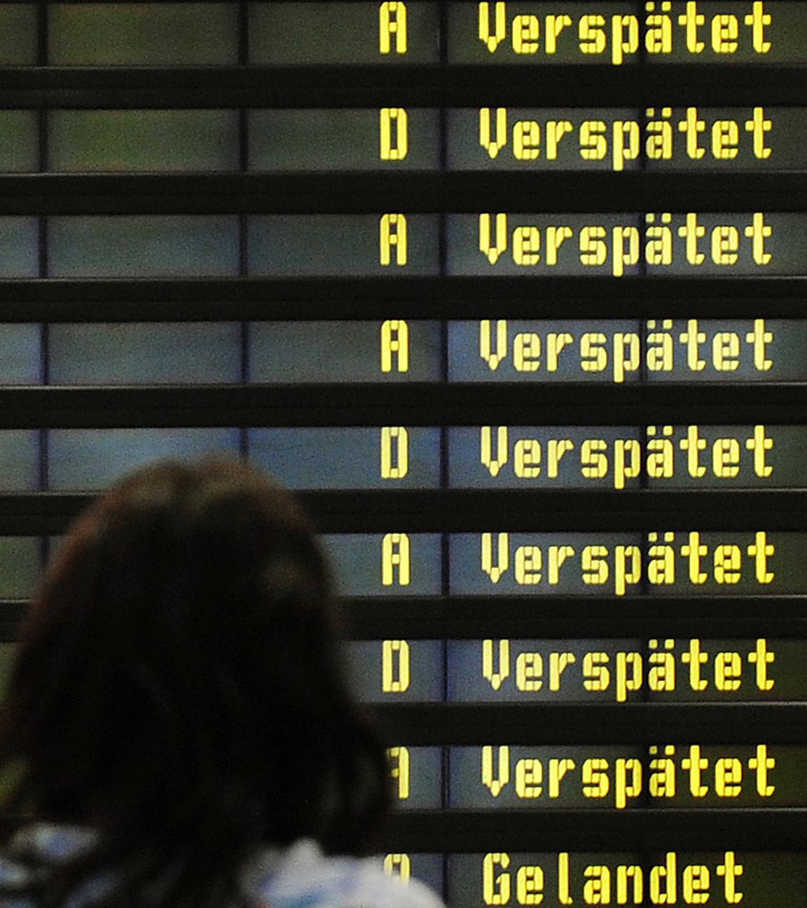 Archiv: Eine Frau steht am 10.12.2010 auf dem Flughafen Berlin-Schönefeld vor einer Anzeigetafel