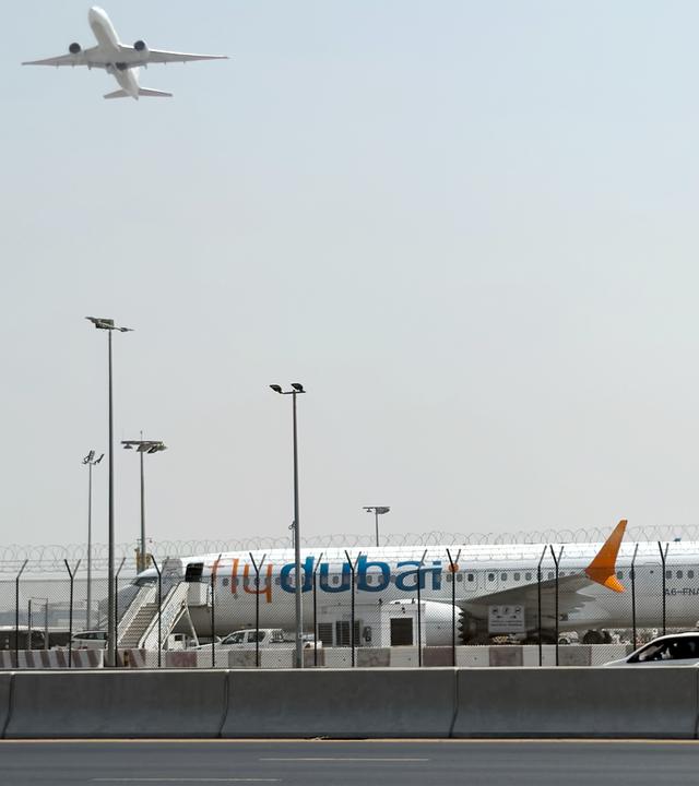 Ein Flugzeug hebt ab, während ein Flugzeug der Fluggesellschaft Flydubai auf dem Rollfeld des Dubai International Airport steht, aufgenommen am 30.09.2026