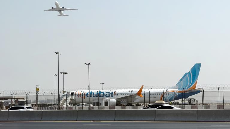 Ein Flugzeug hebt ab, während ein Flugzeug der Fluggesellschaft Flydubai auf dem Rollfeld des Dubai International Airport steht, aufgenommen am 30.09.2026