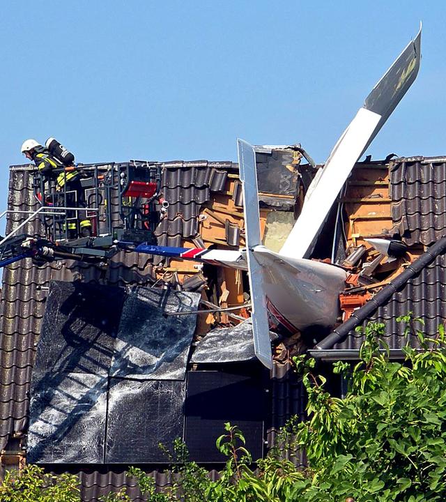  Ein abgestürztes Leichtflugzeug steckt im Dach eines Hauses. 