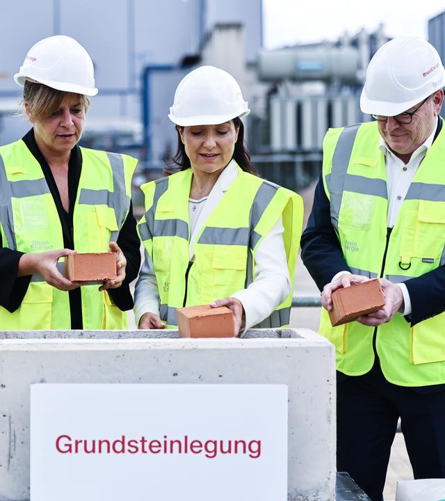 Katherina Reiche (2.v.r., CDU) Bundesministerin für Wirtschaft und Energie, Torsten Burmester (r, SPD), Oberbürgermeister, Mona Neubaur (2.v.l., Grüne), Ministerin für Wirtschaft in Nordrhein-Westfalen, Andreas Feicht, Vorstand der Rheinenergie (l), verschließen bei der Grundsteinlegung für eine Flusswasser-Wärmepumpe den Grundstein.