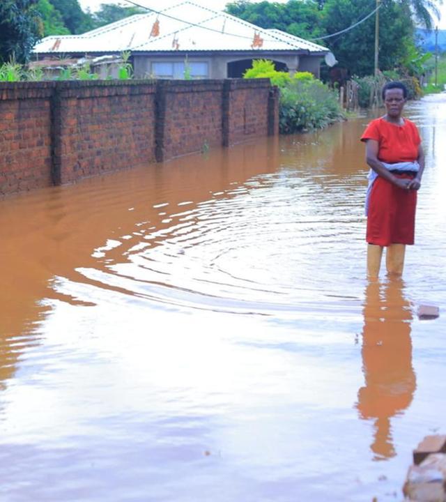 Eine Frau steht in einer überfluteten Straße
