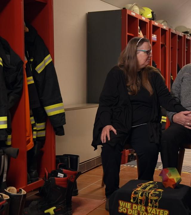 Eheleute Kraatz sitzt neben Spinten der Feuerwehr