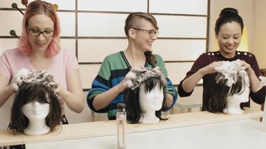 Johanna (li.), Patrizia (mi.) und Linh (re.) shamponieren die Haare der vor sich stehenden Puppenköpfe.