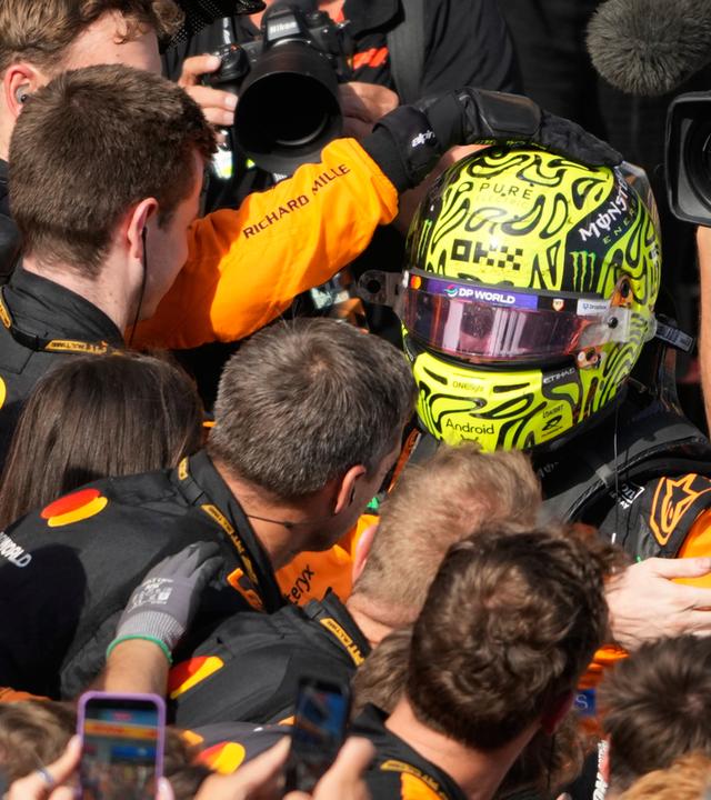 Weltmeister Lando Norris feiert den Sieg beim GP von Ungarn mit seinem McLaren-Team.