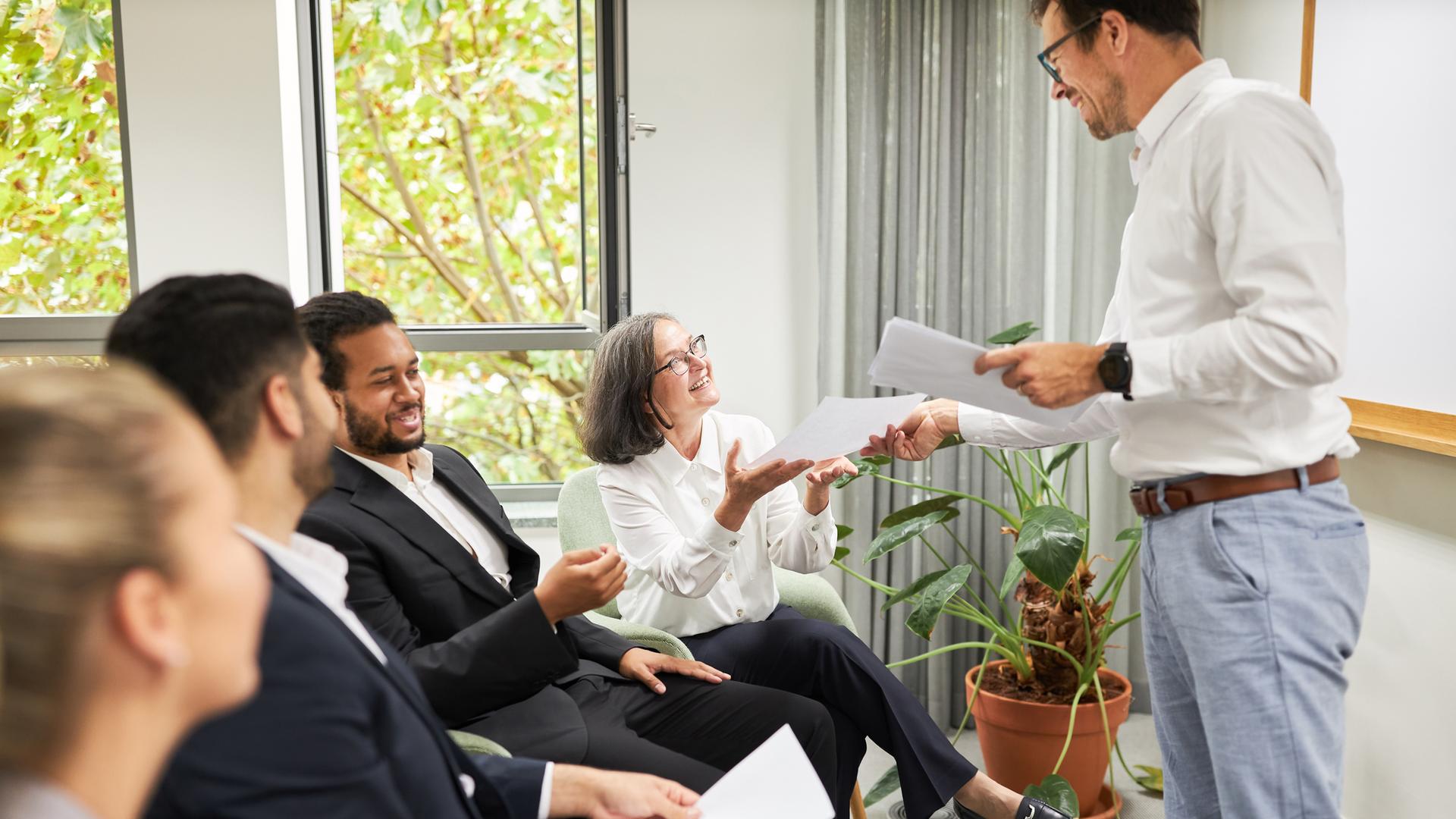 Lehrer verteilt Lehrmaterial an Seminar-Teilnehmende.
