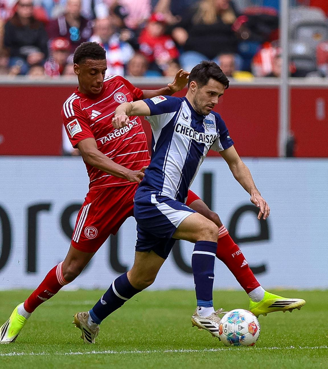 Spieler von Fortuna Düsseldorf und Hertha BSC kämpfen. 