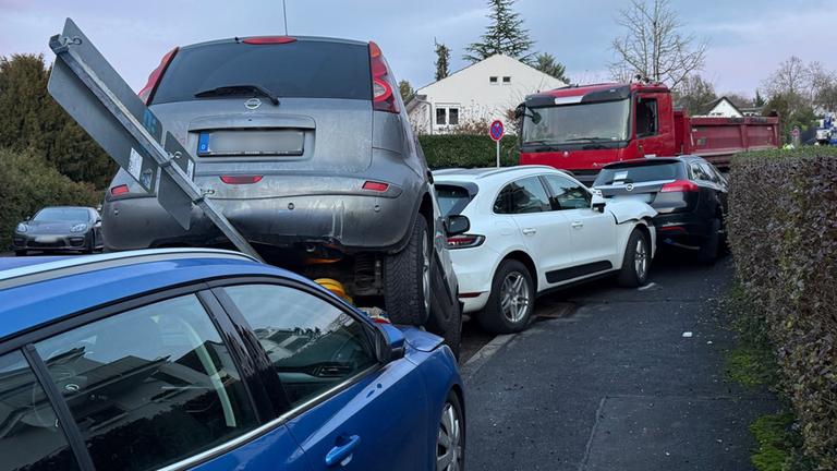 Nach einem Unfall mit einem LKW (hinten) steht ein Auto auf einem anderen. 