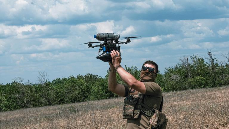Ein Ukrainischer Drohnen Ingenieur nimmt eine Fiberglass Drohne entgegen, die von einem Trainingsflug zurückkehrt.