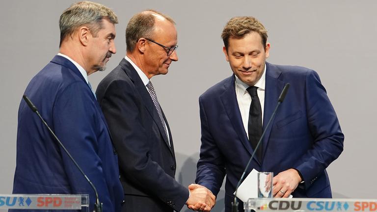 Friedrich Merz und Lars Klingbeil geben sich nach einer Pressekonferenz der Parteivorsitzenden von Union und SPD zur Vorstellung des Koalitionsvertrages die Hand. 