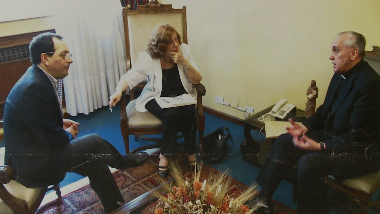 Francesca Ambrogetti und Jorge Bergoglio, der späteren Papst Franziskus, sitzen sich nebeneinander und unterhalten sich.