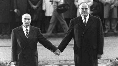 Francois Mitterrand und Helmut Kohl, wie sie während einer deutsch-französischen versöhnungszeremonie vor dem Friedhof von Doaumont händchenhaltend ihre jeweiligen Nationalhymnen hören.