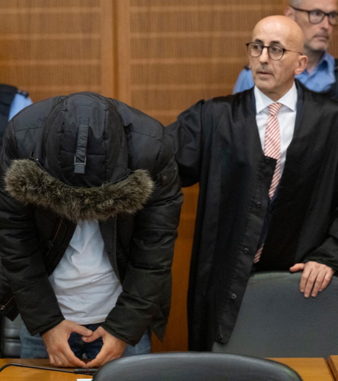 Der angeklagte, syrische Arzt (2.v.l.) steht vor der Urteilsverkündung neben seinem Anwalt Oussama Al-Agi (2.v.r.) im Oberlandesgericht.