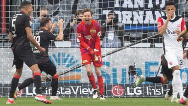 Berlins Torhüter Frederik Rönnow pariert den Handelfmeter von Eintrachts Hugo Ekitike.