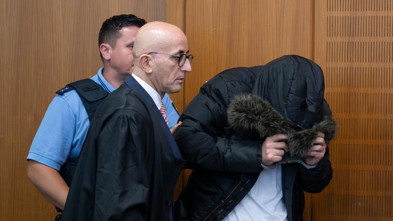 Der angeklagte, syrische Arzt (r) wird neben seinem Anwalt Oussama Al-Agi zur Urteilsverkündung in den Gerichtssaal geführt. Dem Angeklagten wird vorgeworfen, in den Jahren 2011 und 2012 in Syrien in einem Militärkrankenhaus sowie im Gefängnis des Militärgeheimdienstes Gefangene gefoltert und getötet zu haben.