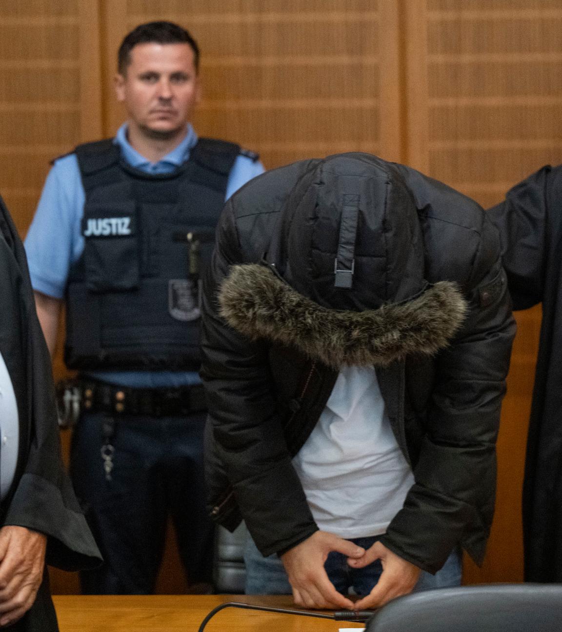 Der angeklagte, syrische Arzt (2.v.l.) steht vor der Urteilsverkündung neben seinem Anwalt Oussama Al-Agi (2.v.r.) im Oberlandesgericht. 