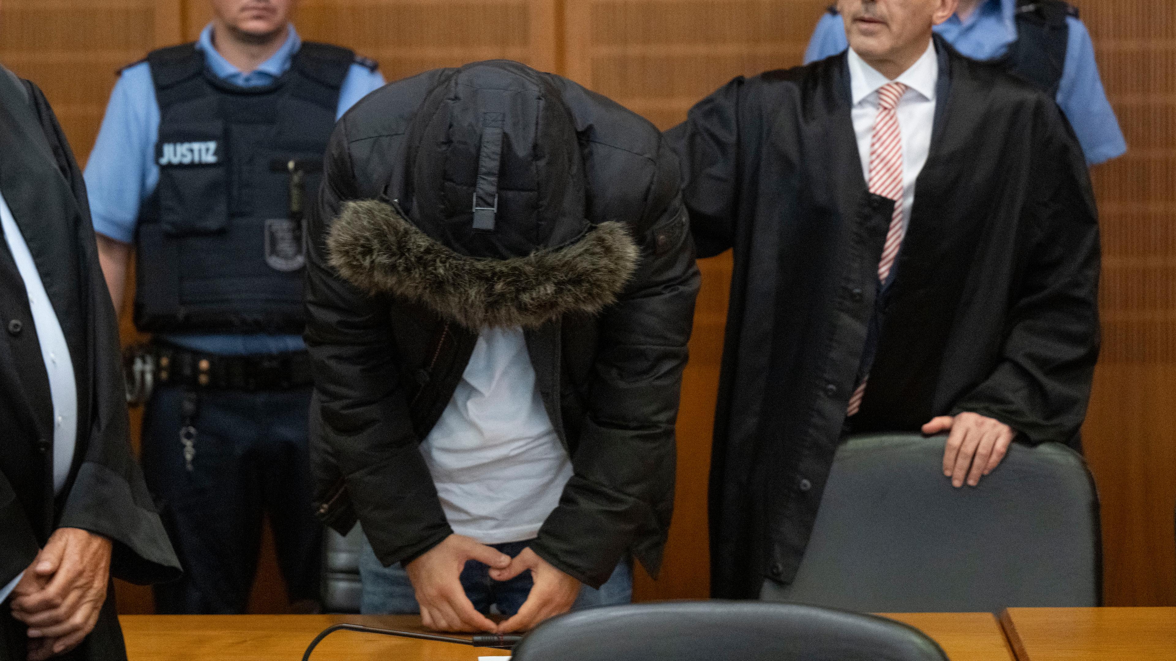 Der angeklagte, syrische Arzt (2.v.l.) steht vor der Urteilsverkündung neben seinem Anwalt Oussama Al-Agi (2.v.r.) im Oberlandesgericht. 