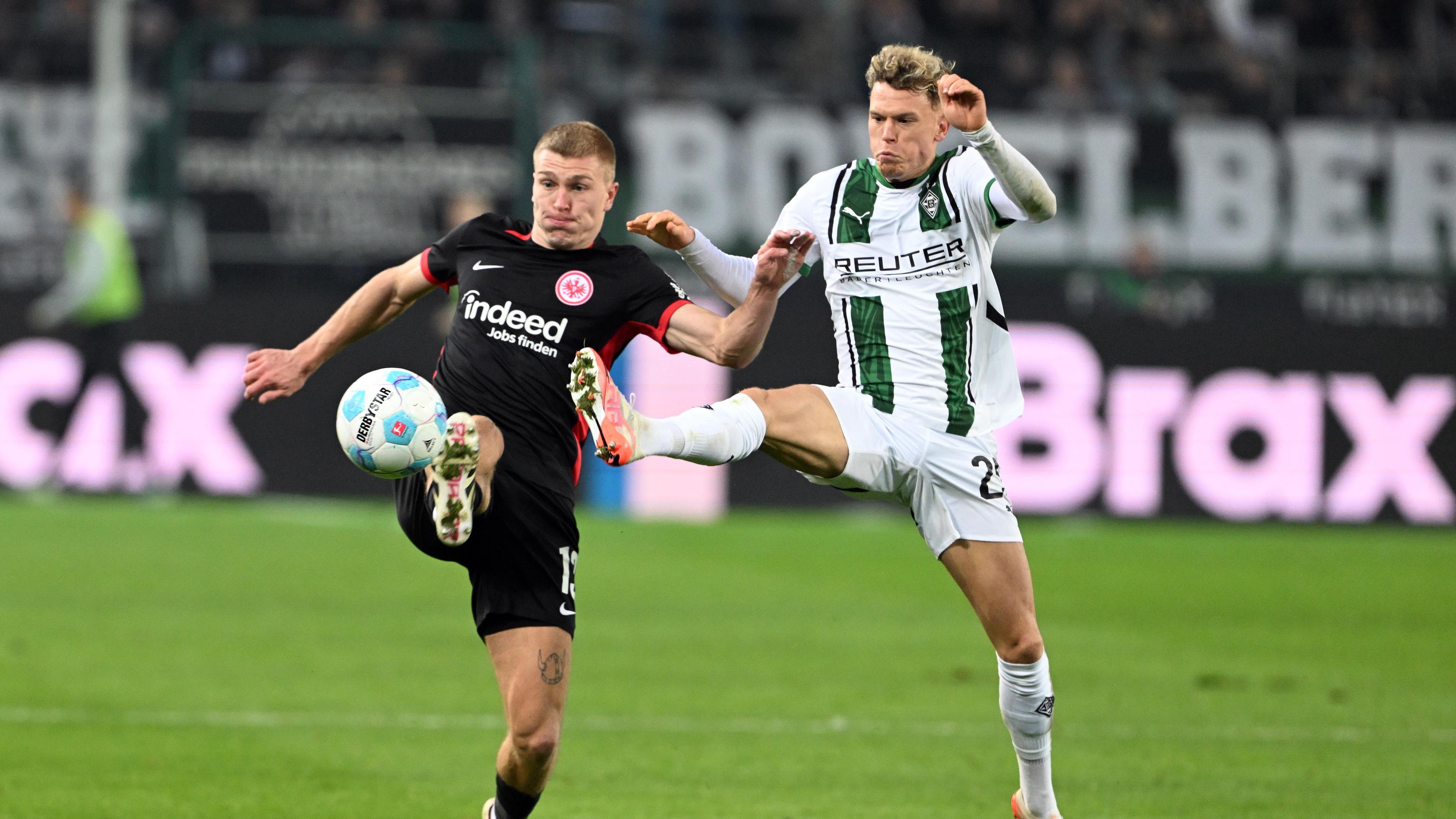 Gladbachs Robin Hack (r) und Frankfurts Rasmus Kristensen kämpfen um den Ball.
