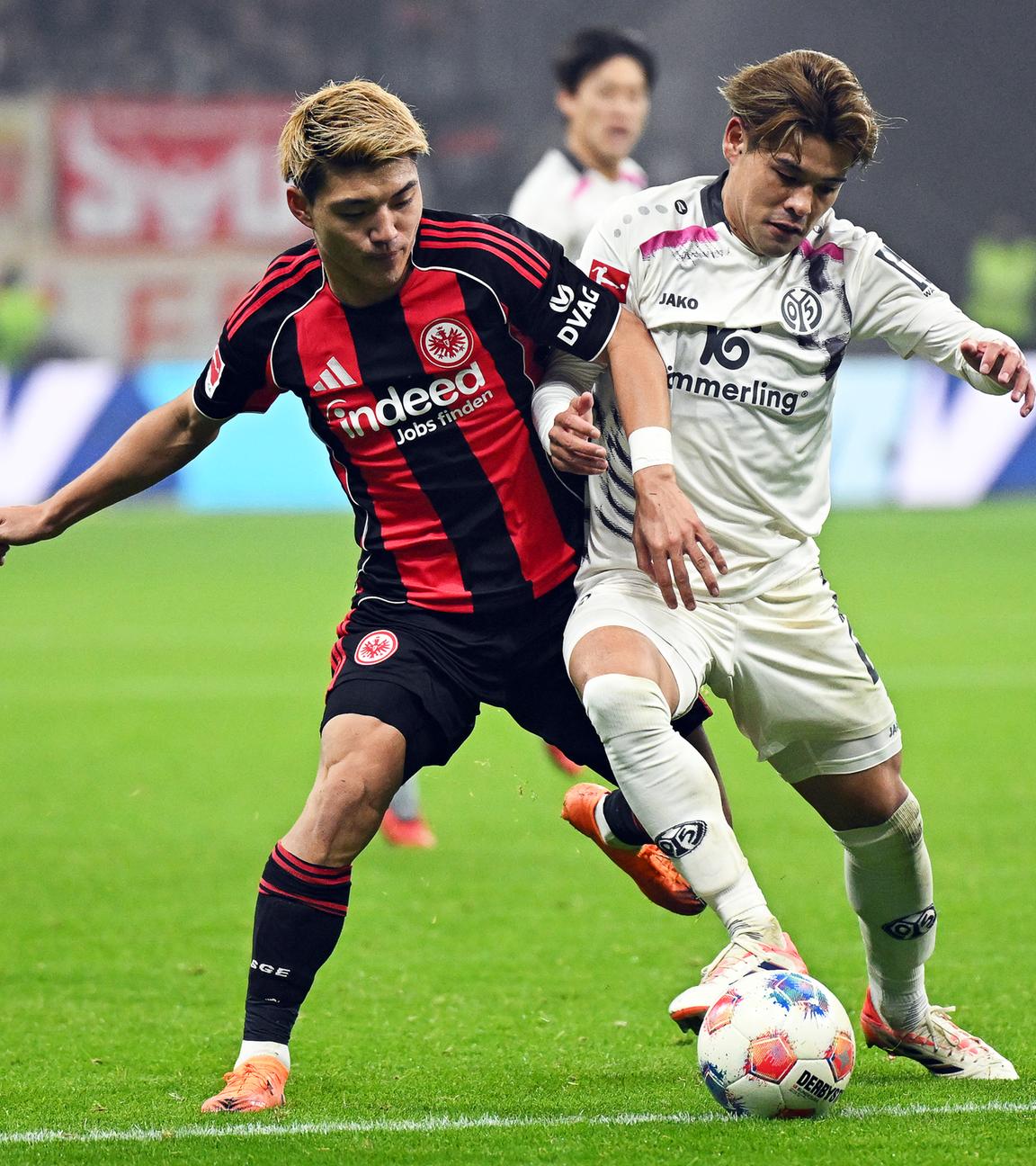 Eintracht Frankfurts Torschütze Ritsu Doan (l.) im Zweikampf mit dem Mainzer Kaishu Sano im Bundesliga-Duell