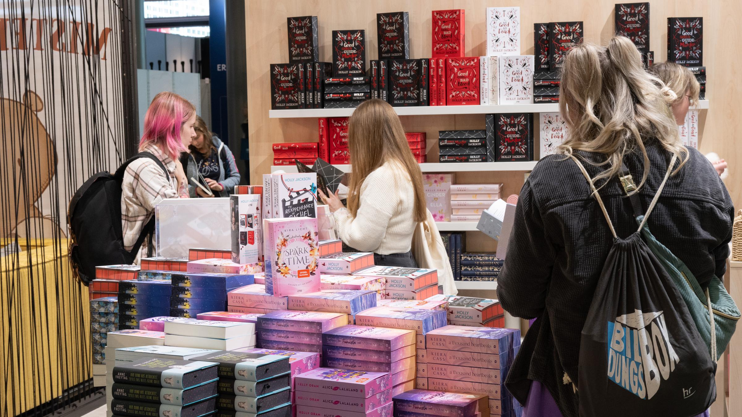 Junge Besucherinnen informieren sich am Stand eines Verlages.