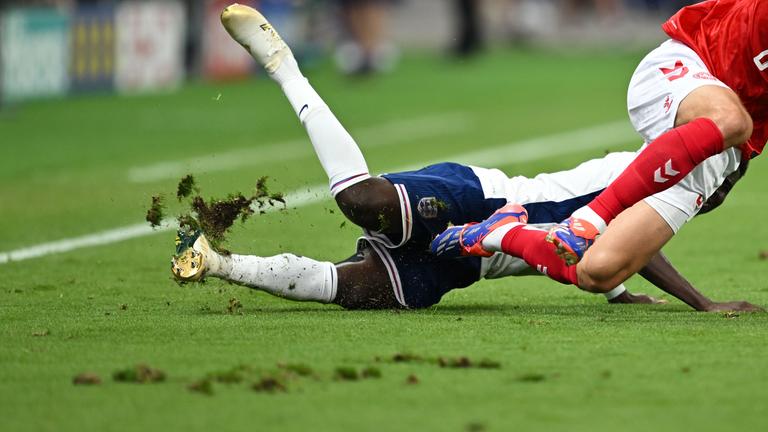Frankfurt Arena, beim Zweikampf zwischen Dänemarks Andreas Christensen (r) und Englands Bukayo Saka fliegt ein Stück Rasen durch die Luft.