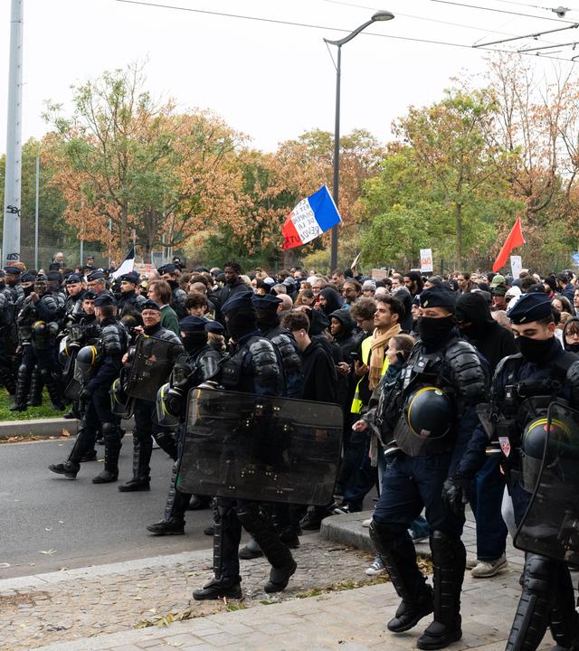Französische Polizisten begleiten Demonstranten zu einem Protest.