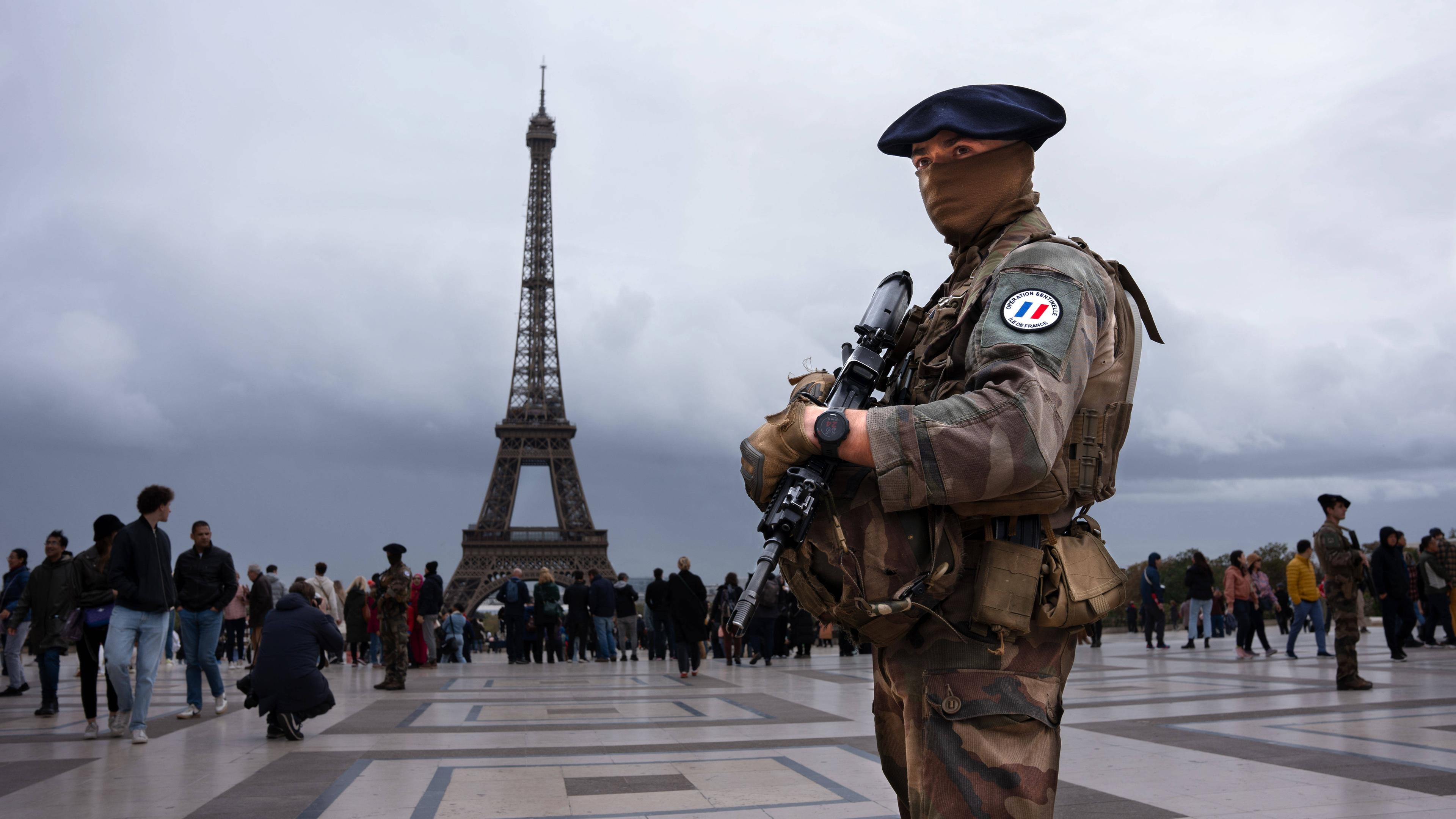 Ein Soldat steht auf dem Trocadero vor dem Eiffelturm in Paris.