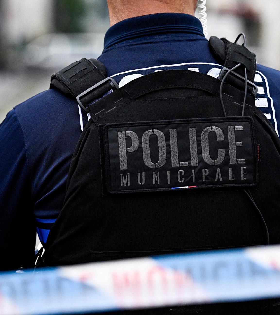 Ein französischer Polizist steht hinter einer Straßenabsperrung.