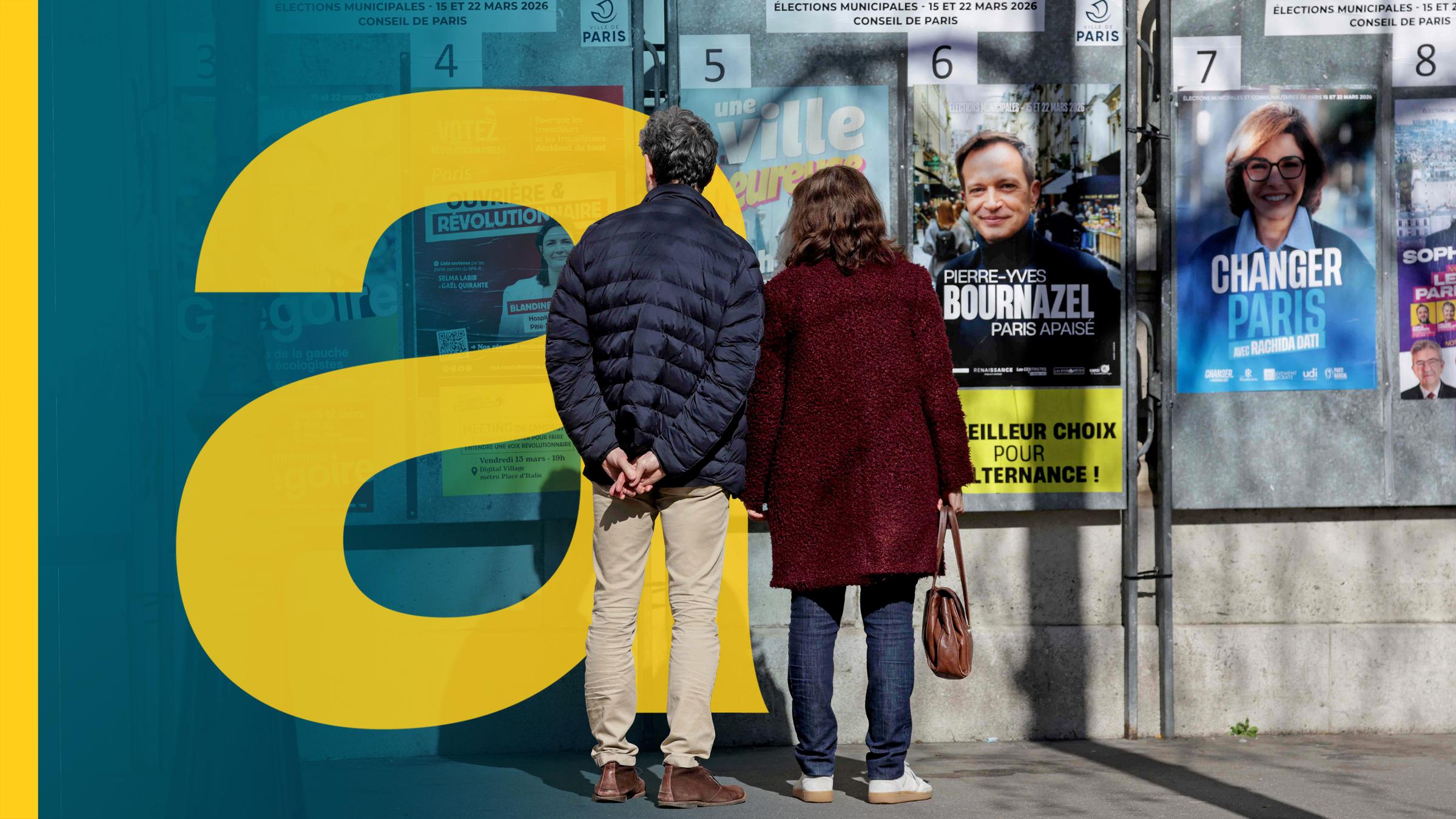 Ein Mann und eine Frau stehen vor den Wahlplakaten in einer französischen Stadt Villers-Cotterêts